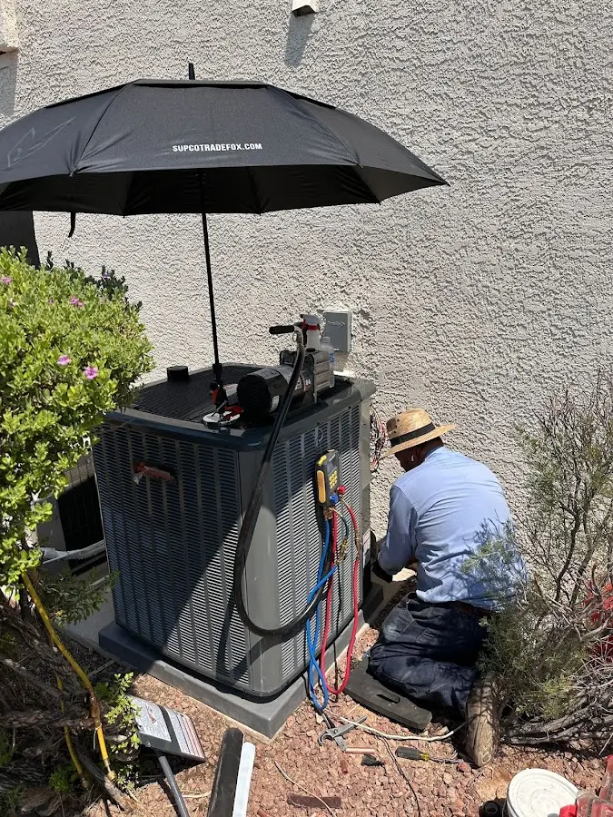 HVAC technician performing outdoor AC maintenance in Ulysses