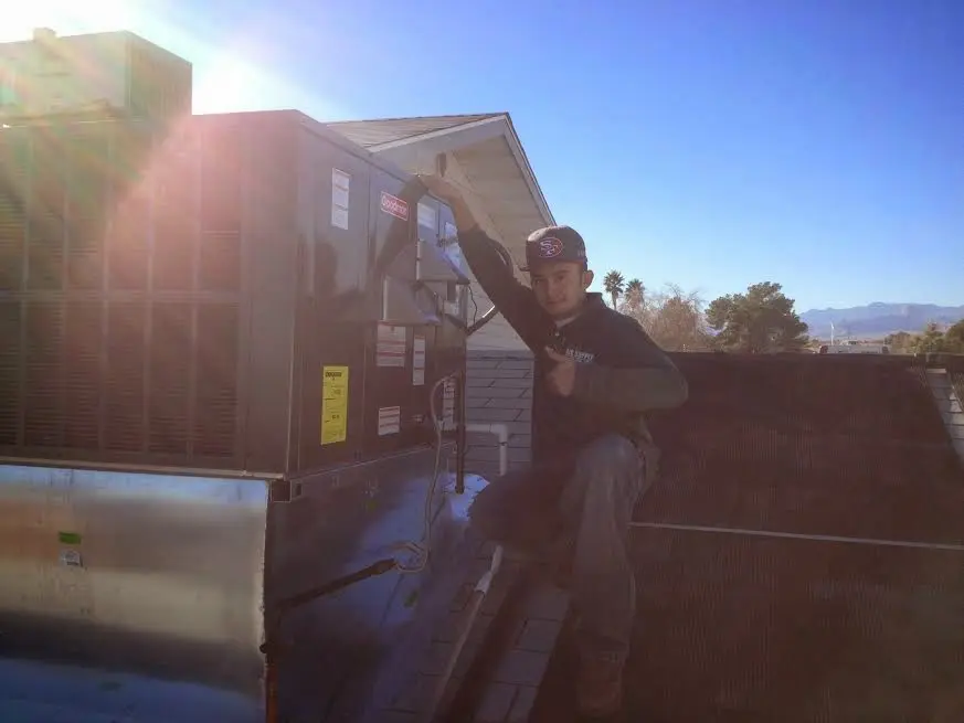 HVAC technician performing Boiler Repair on a rooftop unit in Ulysses